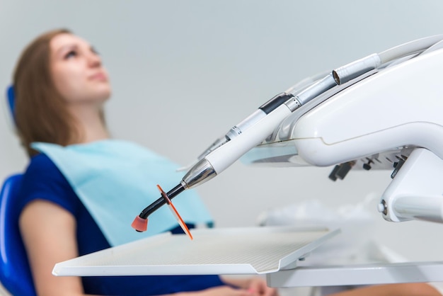 Young girl patient waiting for a doctor in a dental chair at the clinic