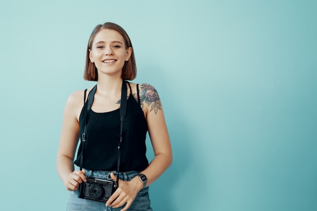 Young girl photographer taking photos on blue background