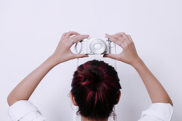 Young girl in pink hair holding camera on white background Back side Cute girly wallpaper