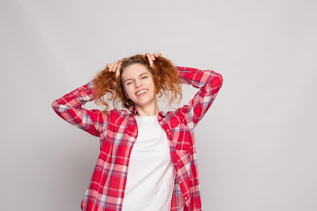 A young girl in a plaid shirt on a light background