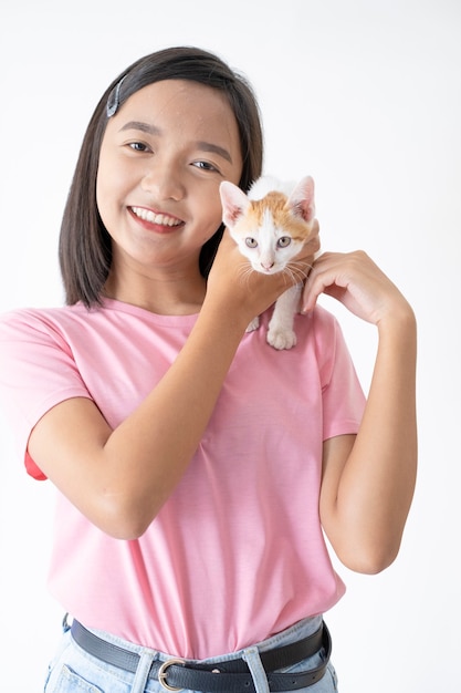 Young girl playing with cat on white background