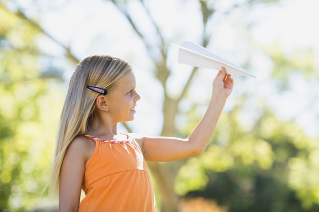 Young girl playing with a paper plane