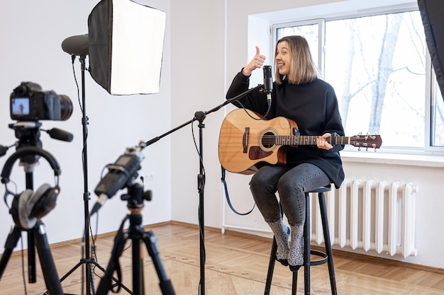 A young girl plays the guitar recording video and sound