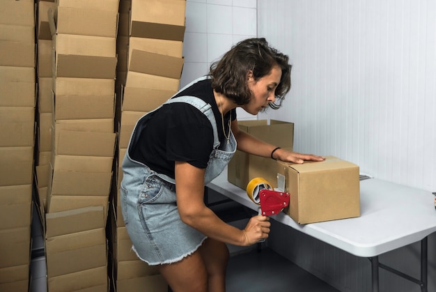 Ragazza che prepara le spedizioni in scatole di cartone in una fabbrica