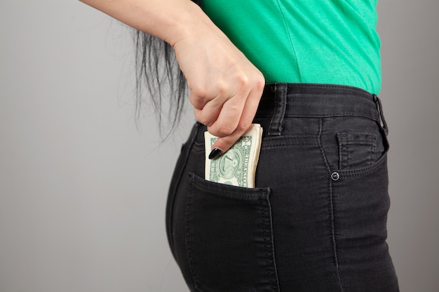 young girl pulls money out of her back pocket
