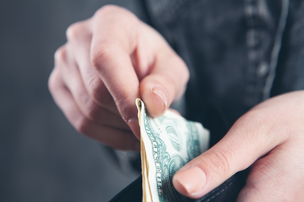 A young girl pulls out bills from a wallet