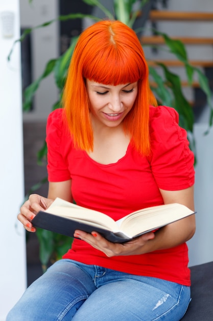 Photo young girl reading a book at home