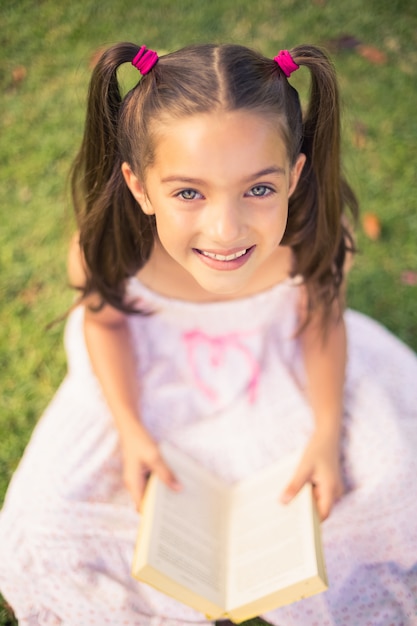 Young girl reading book in park