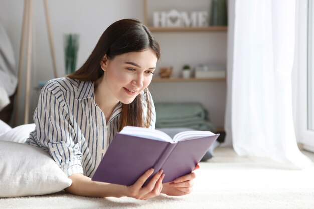 Young girl reads a book at home