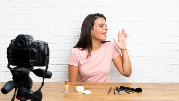 Young girl recording a video tutorial shouting with mouth wide open