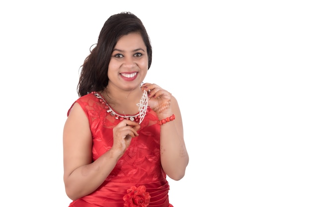 Young girl in red dress posing on white