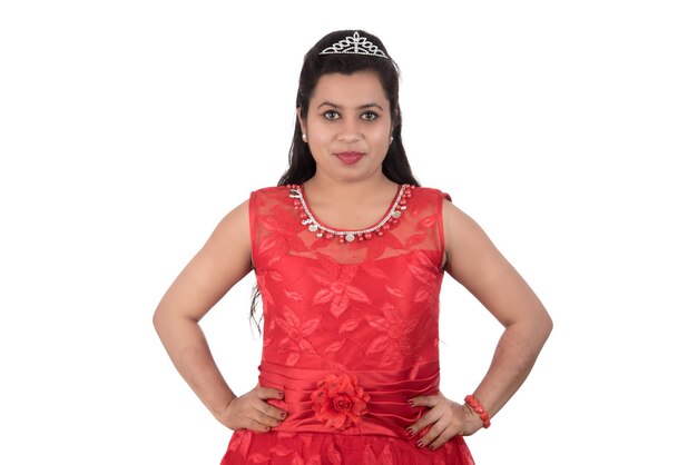 Young girl in red dress posing on white