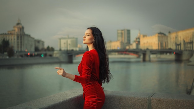 A young girl in a red dress on the waterfront