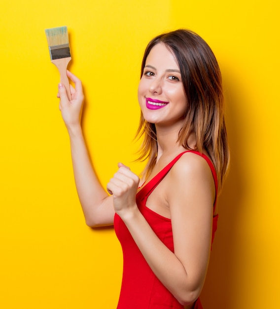 Photo young girl in red dress with brush