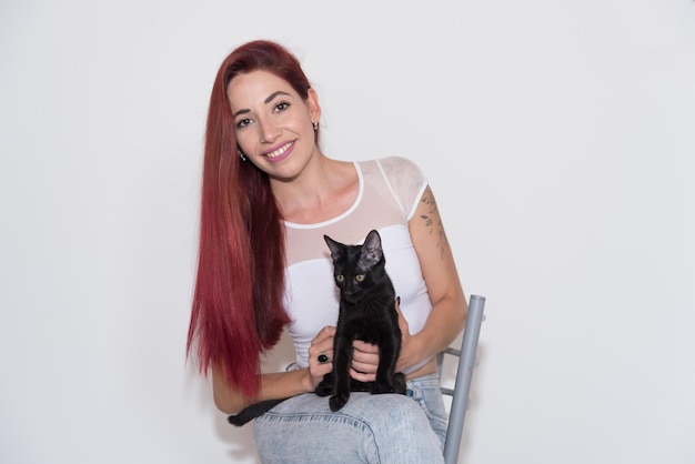 young girl, red-haired, funny, long hair, smiling, expressions, sitting and playing with her black c