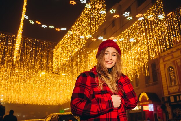 Giovane ragazza con cappello rosso in strada la sera