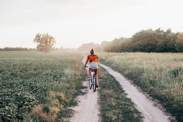 Young girl rides a bike on the road