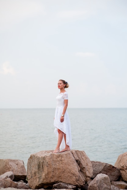 Young girl on the rocks in the sea