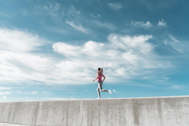 A young girl runs under the blue sky leads an active and healthy lifestyle