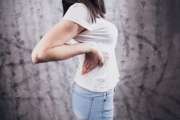 Photo a young girl's back hurts.