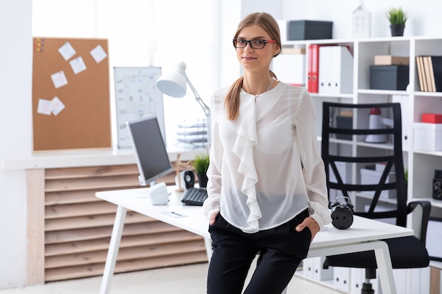 Una ragazza si sedette sul tavolo in ufficio.