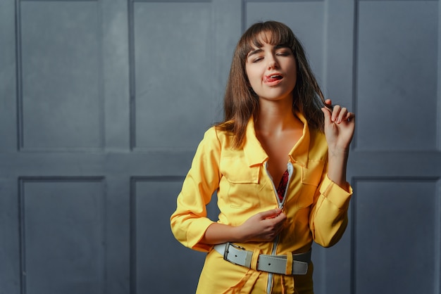 A young girl seductress in a yellow unbuttoned clothes