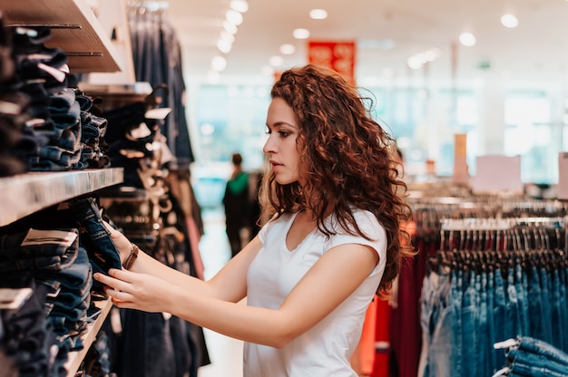 Young girl in shop buying clothes.