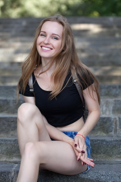 Photo young girl in shorts, sits on the steps. emotional portrait. life style