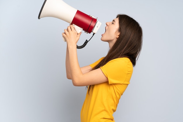 Young girl shouting through a megaphone to announce something in lateral position