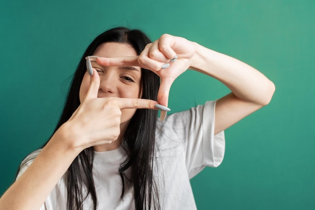 Young girl shows the frame with her hands