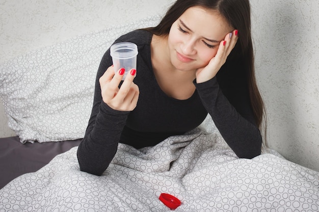 Foto la ragazza si siede su un letto con una banca per l'analisi