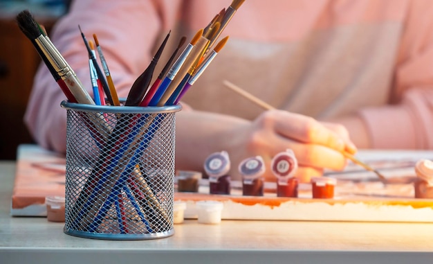 A young girl sits at a table and paints A favorite hobby an activity for the soul