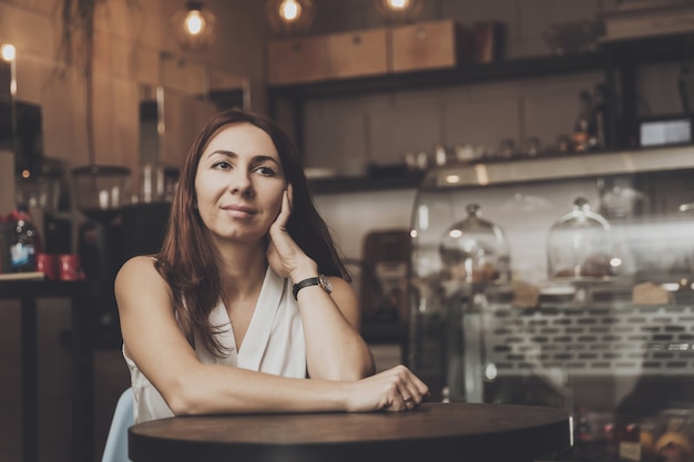 Ragazza che si siede in un caffè che attende un giovane