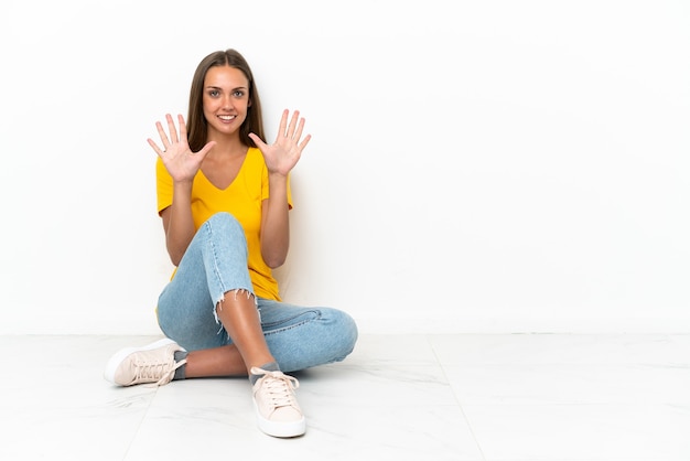 Young girl sitting on the floor counting ten with fingers