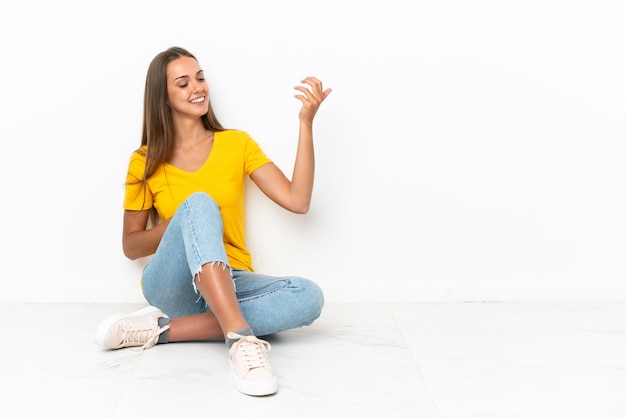 Young girl sitting on the floor making guitar gesture