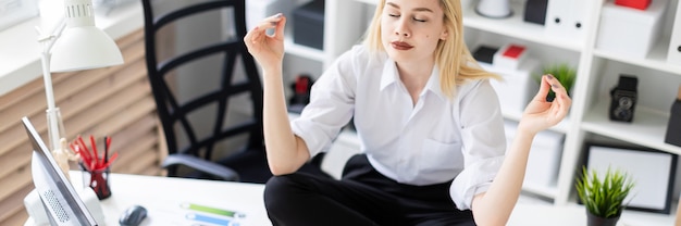 A young girl sitting on a table in the office