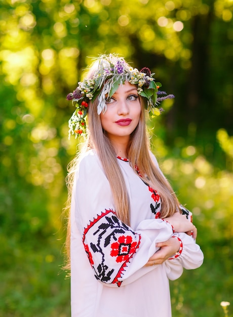 Молодая девушка славянской внешности с венком из полевых цветов в середине лета.