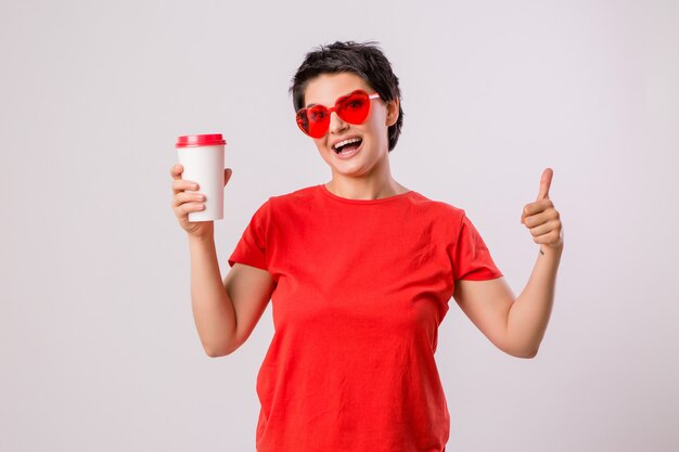 young girl smiling with a glass of coffee on white