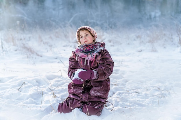 A young girl in a snowcovered forest in winter