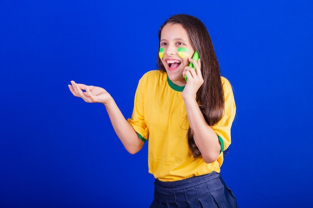 Young girl soccer fan from Brazil holding cellphone voice call Smartphone applications