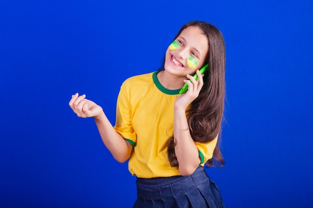 Young girl soccer fan from Brazil holding cellphone voice call Smartphone applications
