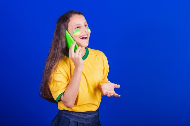 Young girl soccer fan from brazil holding cellphone voice call smartphone applications