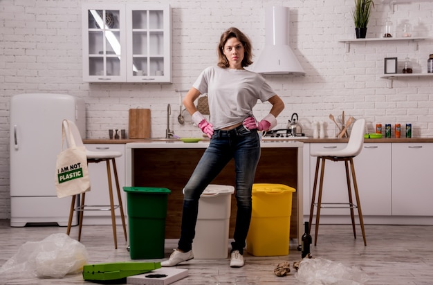 Young girl sorting garbage at the kitchen.