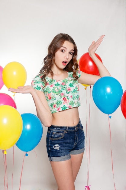 Young girl in summer clothing next to balloons