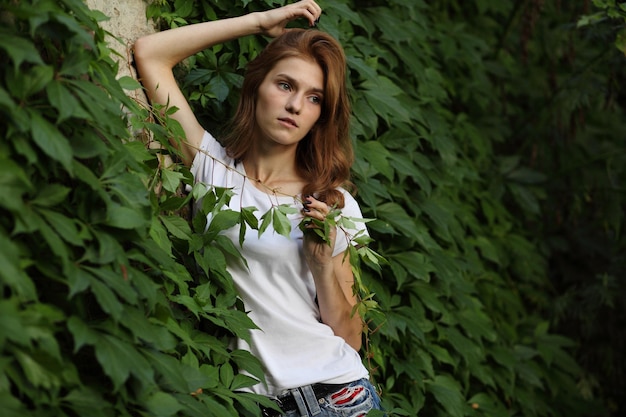 Young girl of summer green park green leaves