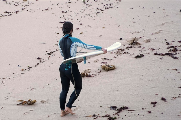 Foto una giovane ragazza che fa surf nell'oceano atlantico