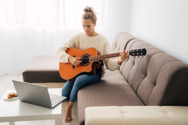 Photo young girl taking an online guitar lesson