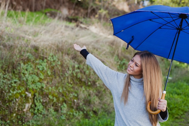 Young girl taking a walk with a blue umbrella