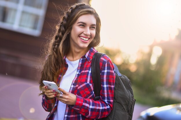 Young girl talking on the phone in the street surfing on the phone