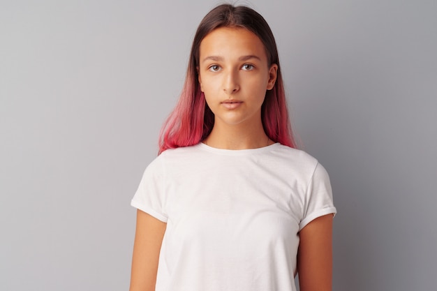 Young girl teenager with pink hair happy and smiling over gray 